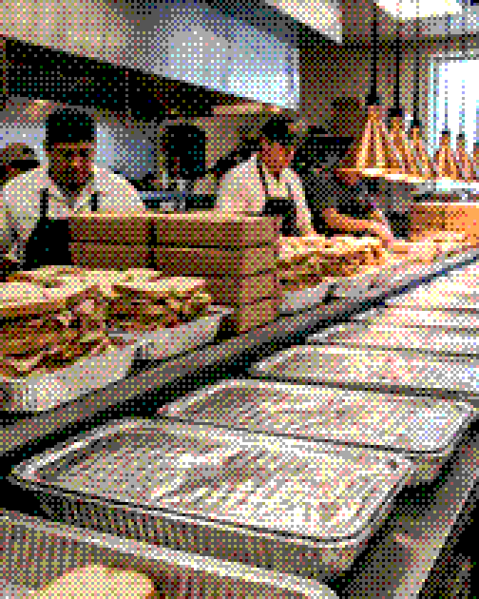 Catering trays lined up on a deli kitchen pass